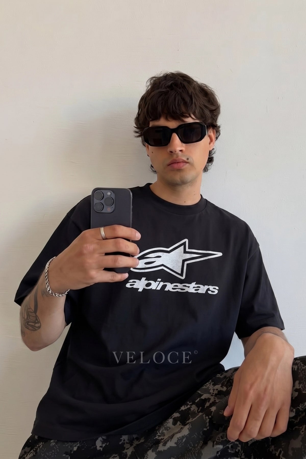 Man in sunglasses wearing the Alpinestars Racing T-Shirt indoors
