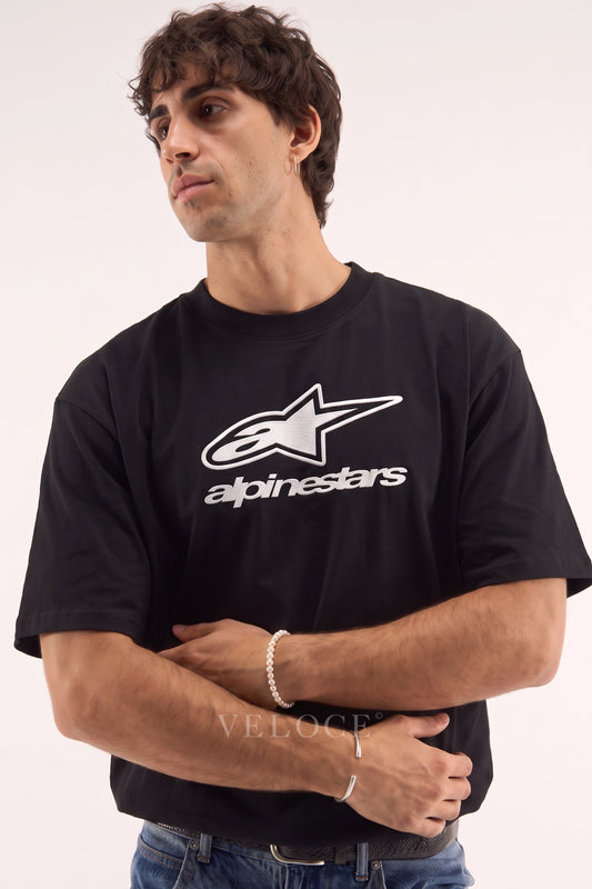 Man wearing the black Alpinestars Racing T-Shirt with the white logo across the chest
