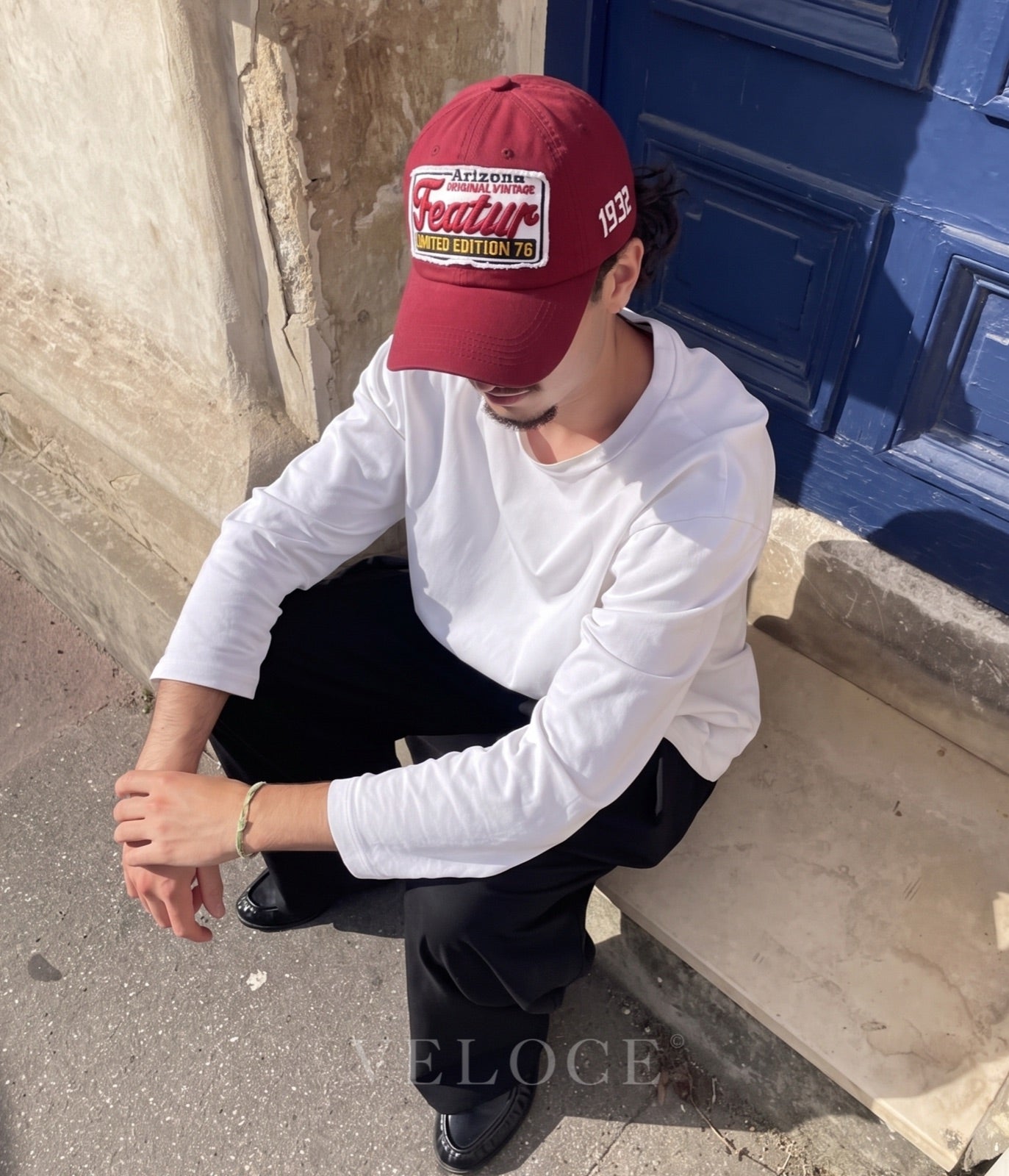 Man wearing the burgundy Arizona Vintage Patch embroidered cap sitting on a doorstep