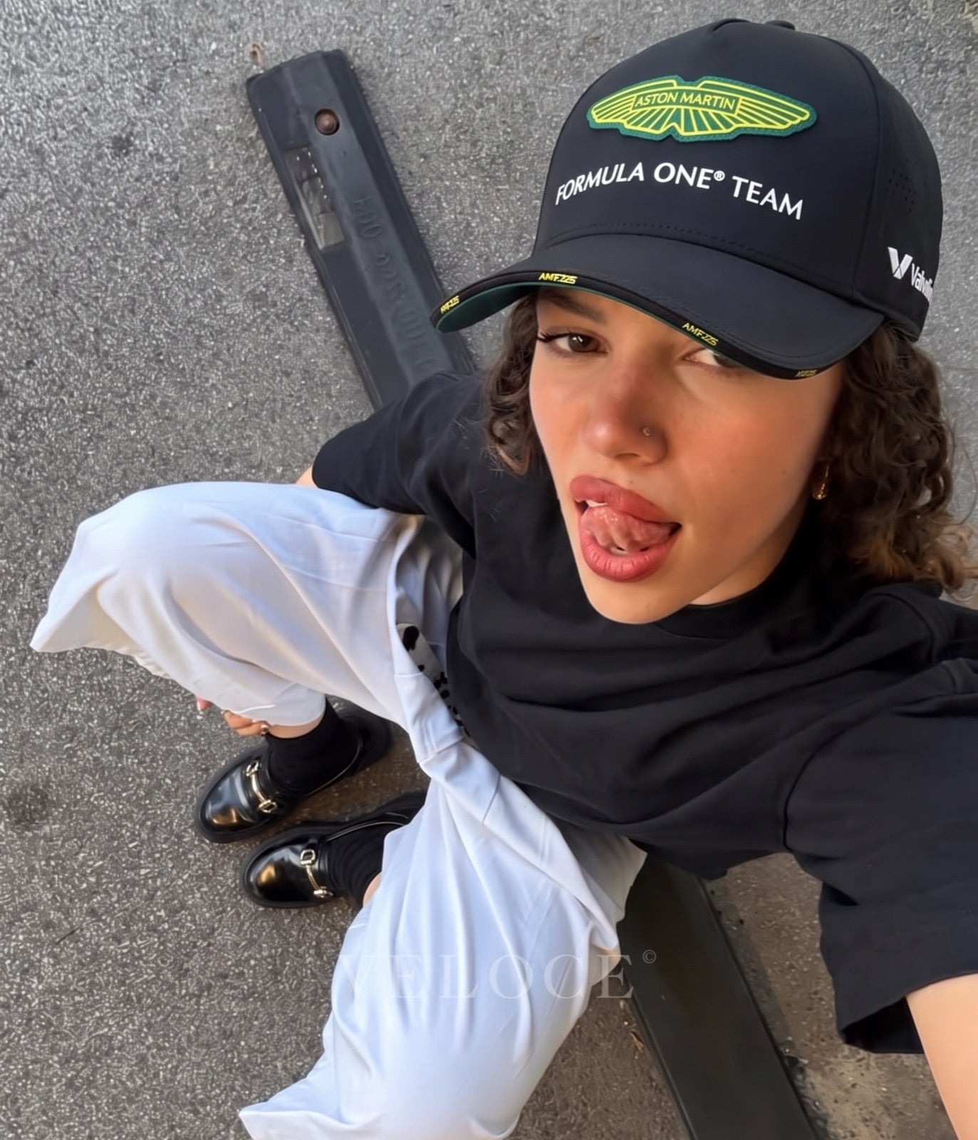 Person wearing the black Aston Martin F1 Team 2025 cap outdoors