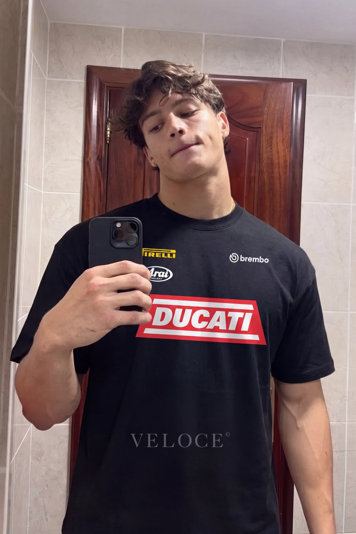 Man taking a mirror photo wearing the Ducati Racing T-Shirt with Pirelli, Arai and Brembo logos