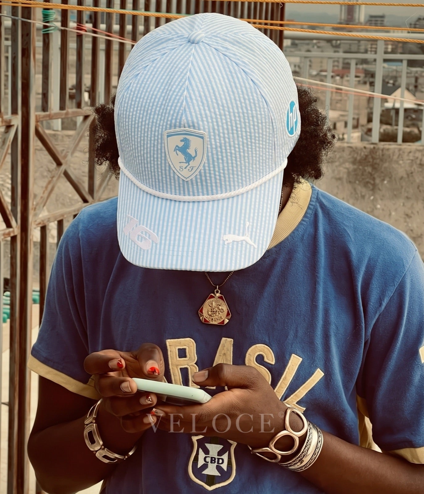 Person wearing the light blue Ferrari F1 2025 seersucker cap on a rooftop