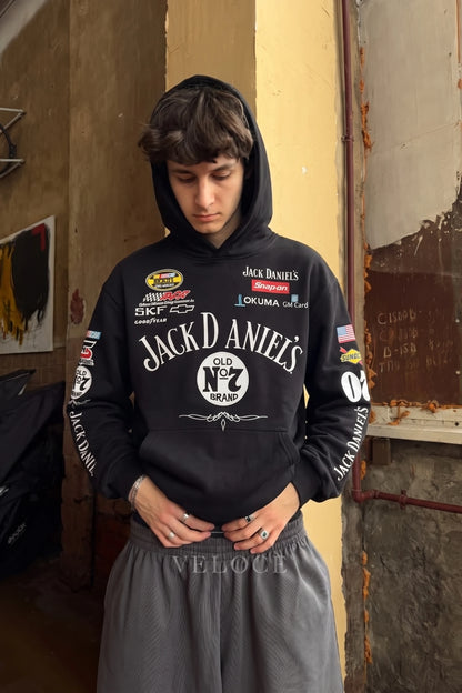Jack Daniel’s embroidered hoodie worn with the hood up against a painted wall