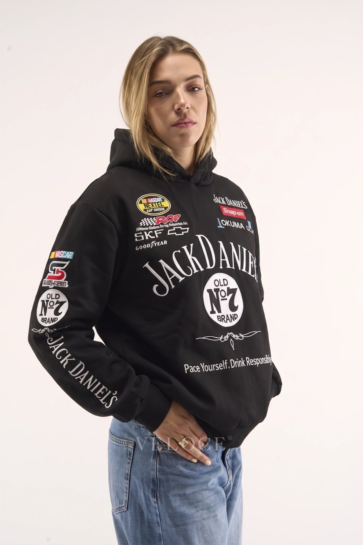 Woman wearing the Jack Daniel’s racing hoodie, front view with the team partner patches