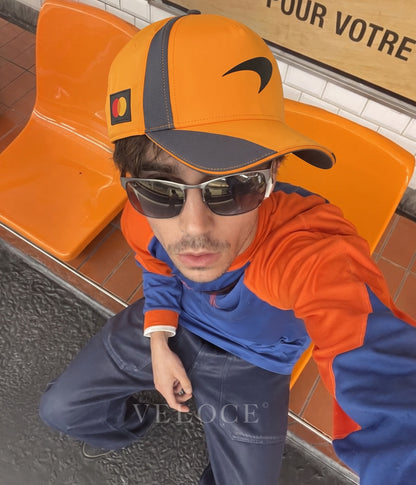 Man wearing the McLaren F1 Team 2025 papaya orange cap with team kit at the circuit