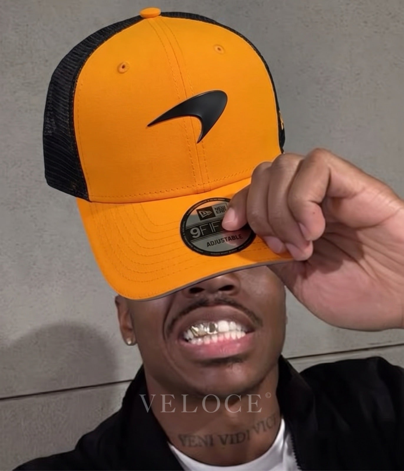 Man holding up the McLaren F1 Team papaya trucker cap