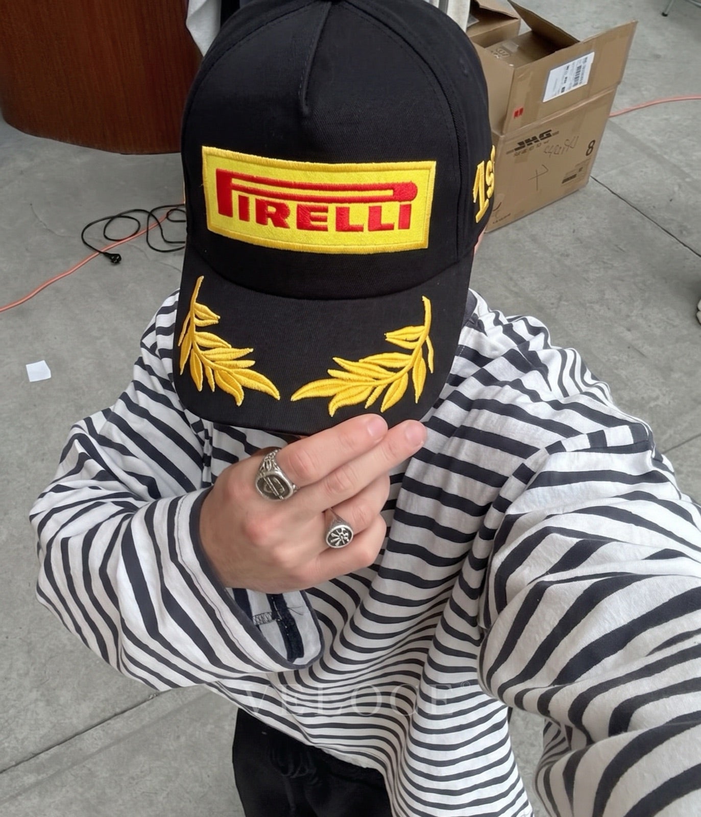Person wearing the black Pirelli F1 podium 1st place embroidered cap