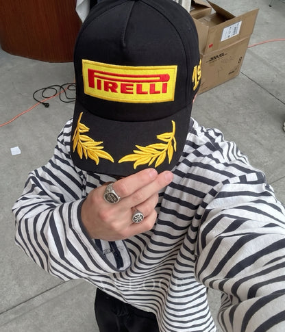 Person wearing the black Pirelli F1 podium 1st place embroidered cap